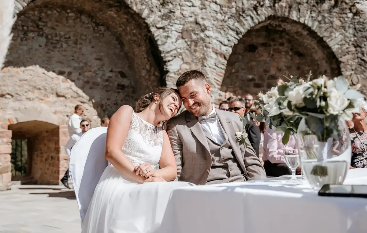 Anja und Dennis lachen bei der freien Trauung vor den Mauern der Burg Windeck